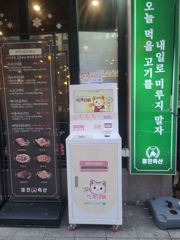 고깃집 메뉴판 옆에 선 럭키넘버 자판기